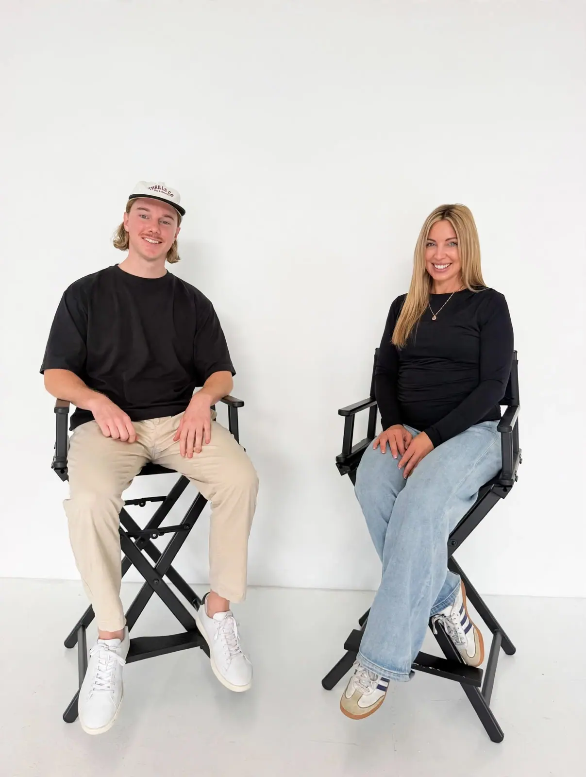 Anthony Bowen and Melissa Brooke seated side by side in a white studio
