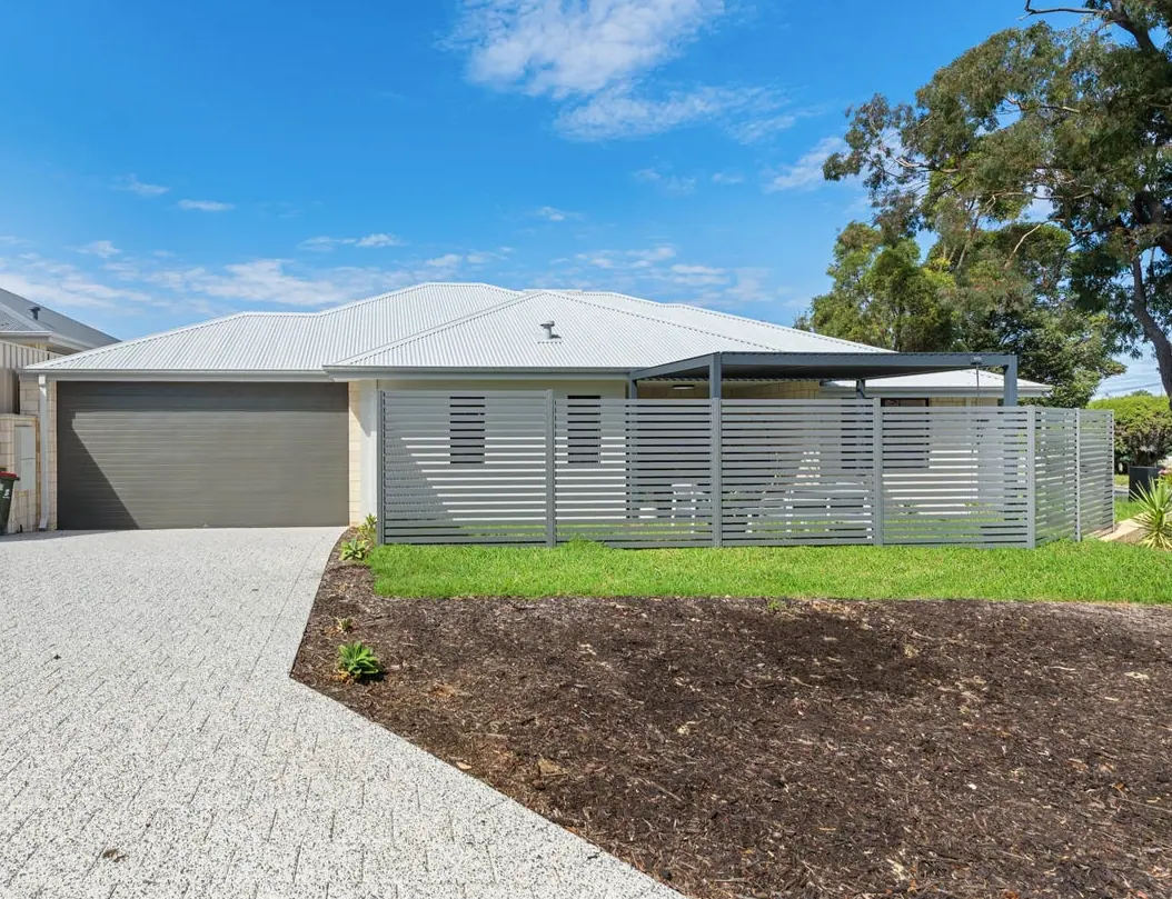 The completed Perth build: a rendered single storey home with a slatted privacy screen and an aggregate driveway